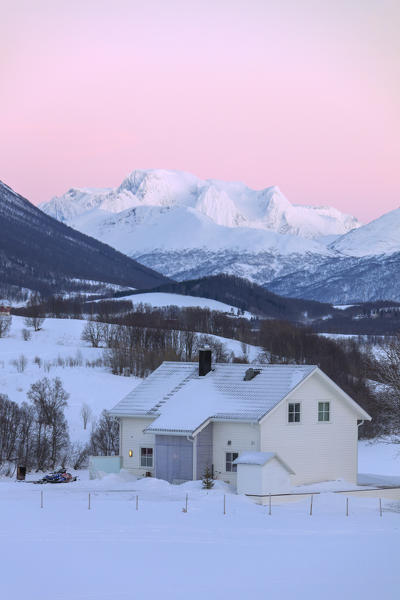 Sunrise on typical house with Lyngen Alps in the background, Mestervik, Troms county, Norway