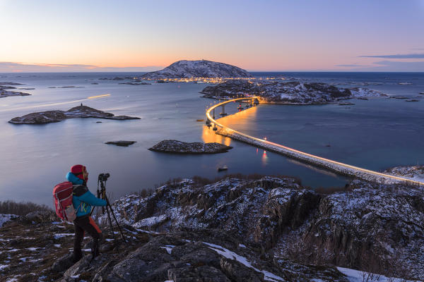 Photographer looks towards bridge and sea, Sommaroy island, Troms county, Norway (MR)