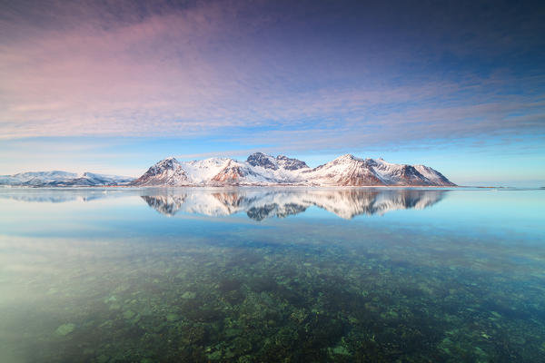 Snowy peaks reflected in the crystalline sea, Grundstad, Lofoten Islands, Norway