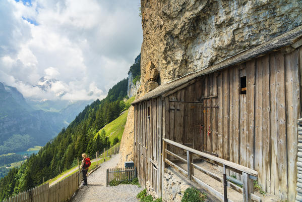 Woman looks at the green valley, Aescher-Wildkirchli Gasthaus, Ebenalp, Appenzell Innerrhoden, Switzerland