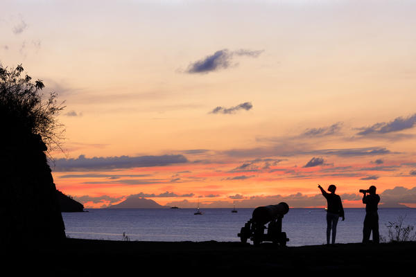 Silhouettes of people and cannon at sunset, Fort James, St. John's, Antigua, Antigua and Barbuda, Leeward Islands, West Indies