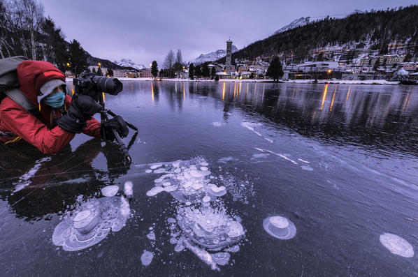 Photographer lying down on frozen Lake St Moritz, canton of Graubunden, Engadine, Switzerland