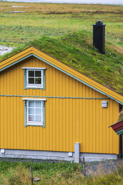 Yellow facade of iconic house with grass roof, Fredvang, Nordland county, Lofoten Islands, Norway