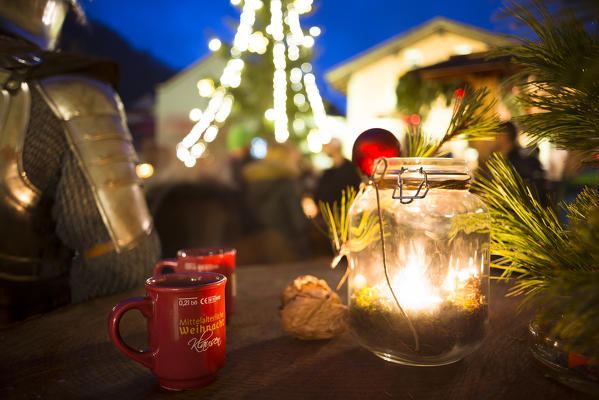 a close up image of a candle into a bottle during the Christmas medieval market in the village of Klausen, Bolzano province, South Tyrol, Trentino Alto Adige, Italy, Europe