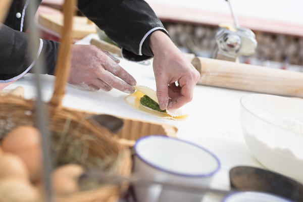 a close up of a cook preparing the slaughter (schlutzkrapfen) stuffed by spinach, Bolzano province, South Tyrol, Trentino Alto Adige, Italy, Europe