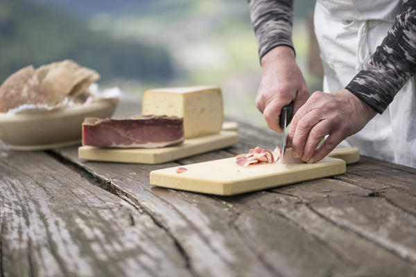 a chef is cutting a piece of Speck, (bacon), Bolzano province, South Tyrol, Trentino Alto Adige, Italy, 