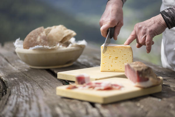 a chef is cutting a piece of cheese, Bolzano province, South Tyrol, Trentino Alto Adige, Italy,