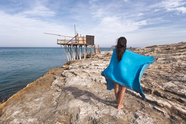 A girl looking at the Trabocco of Punta San Lorenzo, Vieste, Gargano, Apulia, Italy, Europe