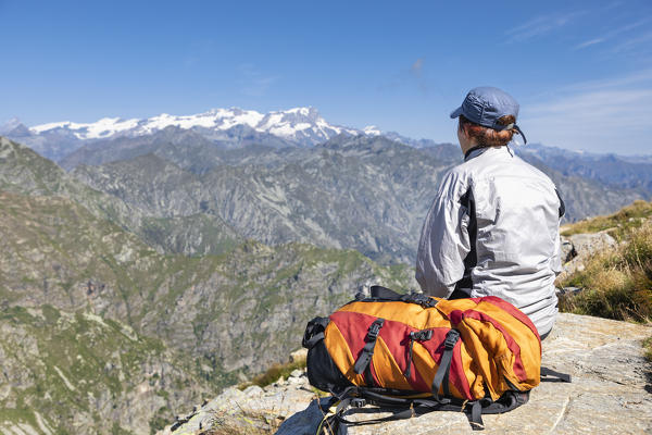 A girl is watching the Monte Rosa Massif from the Monte Camino on the mountains of Biella above Oropa (Oropa Valley, Biella, Biella province, Piedmont, Italy, Europe)
