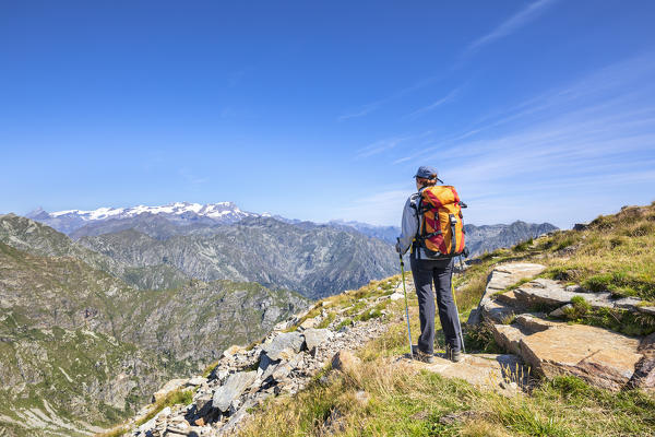 A girl is watching the Monte Rosa Massif from the Monte Camino on the mountains of Biella above Oropa (Oropa Valley, Biella, Biella province, Piedmont, Italy, Europe)
