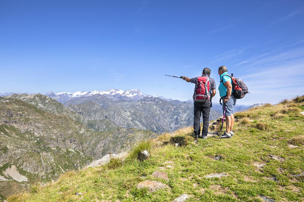 Hikers are watching the Monte Rosa Massif from the Monte Camino on the mountains of Biella above Oropa (Oropa Valley, Biella, Biella province, Piedmont, Italy, Europe)
