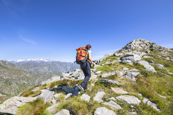 A girl is walking towards the Monte Camino on the mountains of Biella above Oropa: the Matterhorn and the Monte Rosa in the left. (Oropa Valley, Biella, Biella province, Piedmont, Italy, Europe)
