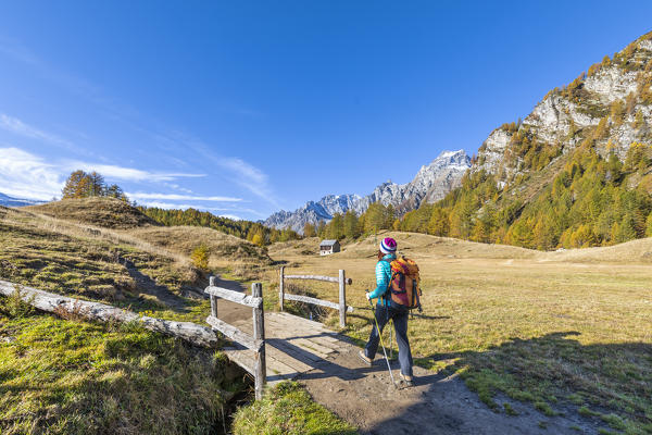 A girl is walking near Alp Crampiolo in autumn season, Alpe Veglia and Alpe Devero Natural Park (Alpe Devero, Baceno, Antigorio Valley, Verbano Cusio Ossola province, Piedmont, Italy, Europe) (MR)