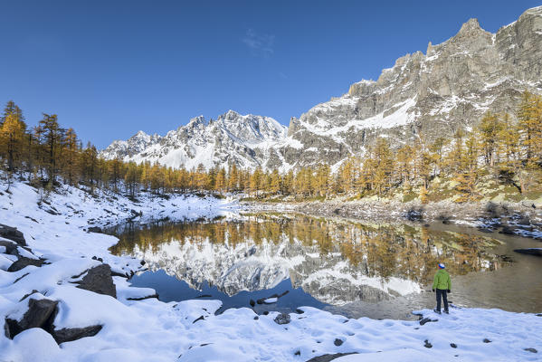 A trekker in front of the Nero Lake in autumn (Buscagna Valley, Alpe Devero, Alpe Veglia and Alpe Devero Natural Park, Baceno, Verbano Cusio Ossola province, Piedmont, Italy, Europe) (MR)