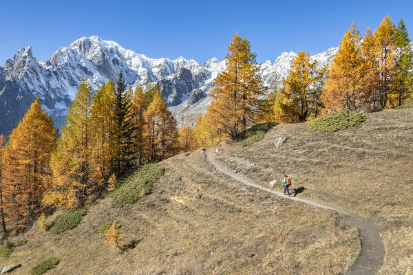 View of the Mont Blanc Massif: a trekker is walking to the Bonatti Refuge during the Mont Blanc hiking tours (Ferret Valley, Courmayeur, Aosta province, Aosta Valley, Italy, Europe) (MR)