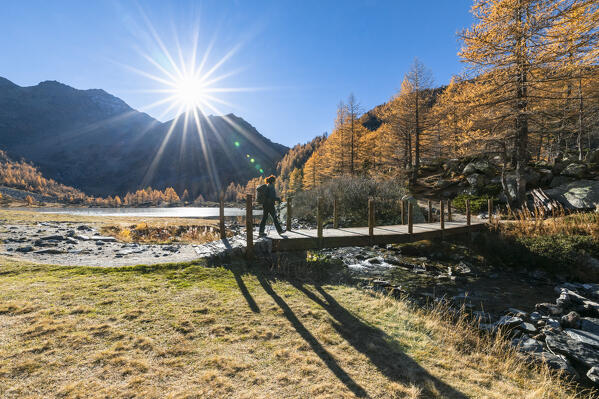 A girl is walking at Arpy Lake in autumn season (Morgex, Aosta province, Aosta Valley, Italy, Europe) (MR)