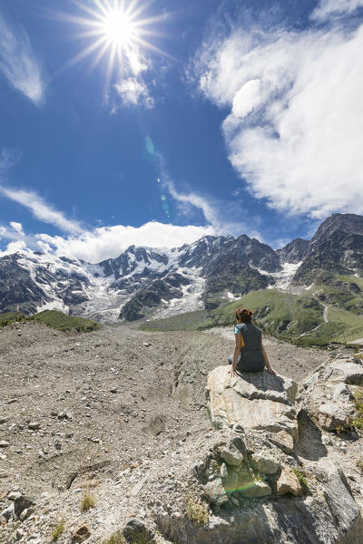 A girl enjoy in front of the East face of the Monte Rosa Massif and the Belvedere Glacier (Belvedere, Macugnaga, Anzasca Valley, Verbano Cusio Ossola province, Piedmont, Italy, Europe)