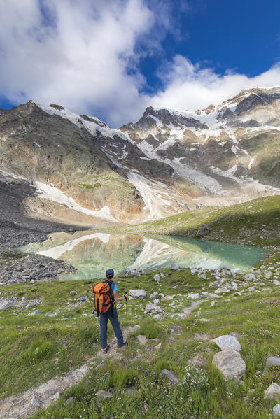 A girls looks the Locce Lake and the East face of Monte Rosa Massif (Locce Lake, Macugnaga, Anzasca Valley, Verbano Cusio Ossola province, Piedmont, Italy, Europe)