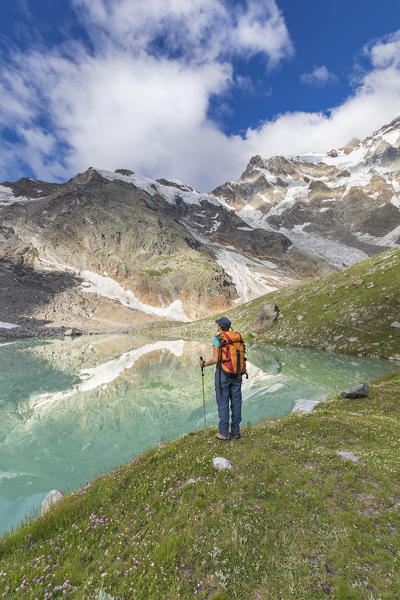 A girls looks the Locce Lake at the foot of the East face of Monte Rosa Massif (Locce Lake, Macugnaga, Anzasca Valley, Verbano Cusio Ossola province, Piedmont, Italy, Europe)