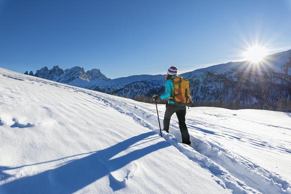 A trekker is walking at sunset near San Pellegrino Pass, in front of Her the Pale Group, Pale di San Martino (Fuciade, Soraga di Fassa, Biois Valley, Trento province, Trentino-Alto Adige, Italy, Europe) (MR)
