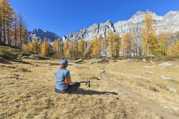 A girl is relaxing near the Nero Lake in the Alpe Veglia and Alpe Devero Natural Park (Buscagna Valley, Alpe Devero, Baceno, Verbano Cusio Ossola province, Piedmont, Italy, Europe) (MR)