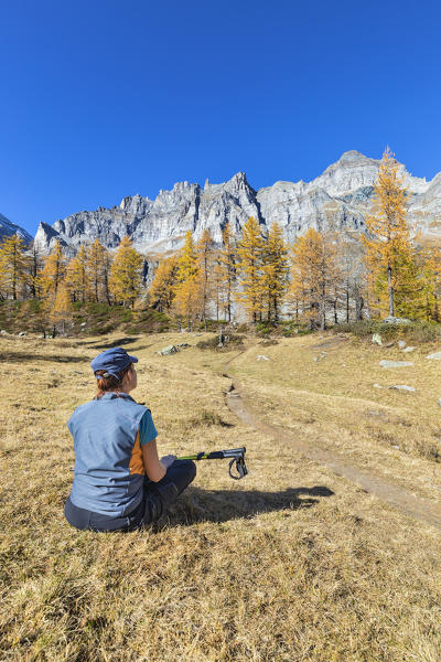 A girl is relaxing near the Nero Lake in the Alpe Veglia and Alpe Devero Natural Park (Buscagna Valley, Alpe Devero, Baceno, Verbano Cusio Ossola province, Piedmont, Italy, Europe) (MR)