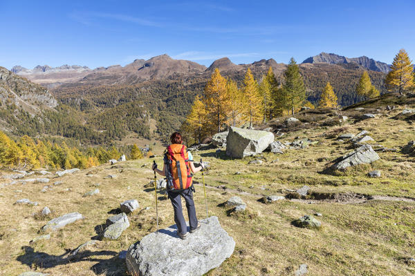 A girl is looking at the Alpe Veglia and Alpe Devero Natural Park in autumn season (Buscagna Valley, Alpe Devero, Baceno, Verbano Cusio Ossola province, Piedmont, Italy, Europe) (MR)
