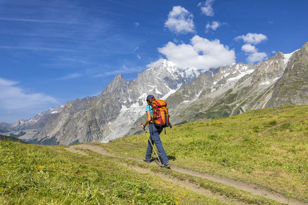 A trekker is walking in front of the Mont Blanc during the Mont Blanc hiking tours (Ferret Valley, Courmayeur, Aosta province, Aosta Valley, Italy, Europe) (MR)
