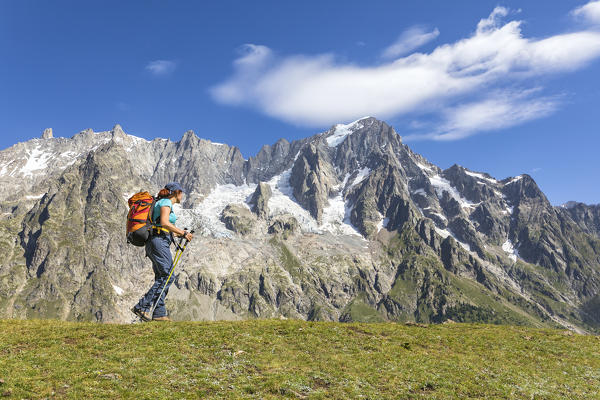 A trekker is walking in front of the Grandes Jorasses during the Mont Blanc hiking tours (Ferret Valley, Courmayeur, Aosta province, Aosta Valley, Italy, Europe) (MR)
