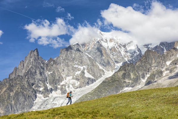 A trekker is walking in front of the Mont Blanc during the Mont Blanc hiking tours (Ferret Valley, Courmayeur, Aosta province, Aosta Valley, Italy, Europe) (MR)
