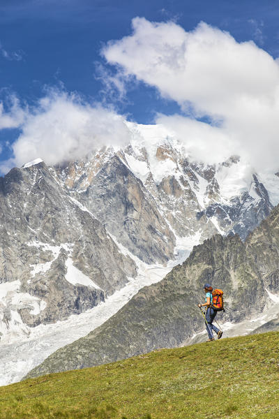 A trekker is walking in front of the Mont Blanc during the Mont Blanc hiking tours (Ferret Valley, Courmayeur, Aosta province, Aosta Valley, Italy, Europe) (MR)
