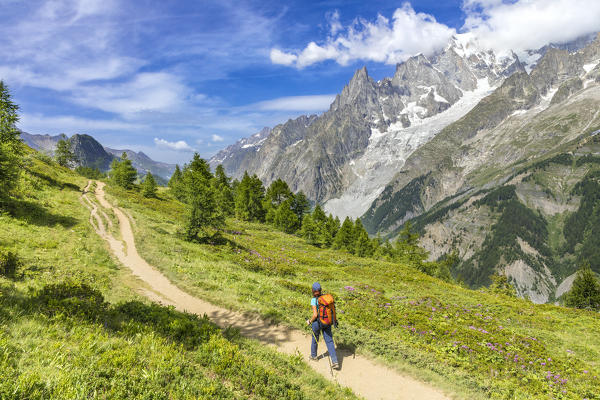 View of the Mont Blanc Massif: a trekker is walking to the Bertone Refuge during the Mont Blanc hiking tours (Ferret Valley, Courmayeur, Aosta province, Aosta Valley, Italy, Europe) (MR)
