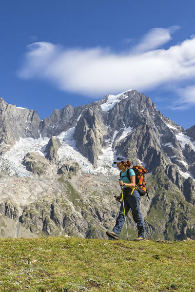 A trekker is walking in front of the Grandes Jorasses during the Mont Blanc hiking tours (Ferret Valley, Courmayeur, Aosta province, Aosta Valley, Italy, Europe) (MR)
