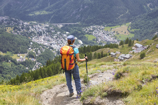 A girl is watching the village of Courmayeur from the top during the Mont Blanc hiking tours (Mont de la Saxe, Ferret Valley, Courmayeur, Aosta province, Aosta Valley, Italy, Europe) (MR)
