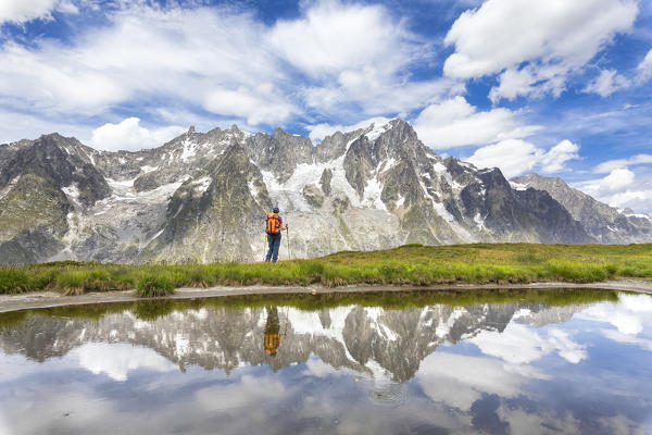 A girl is watching the Grandes Jorasses and the Mont Blanc Massif from the Mont de la Saxe during the Mont Blanc hiking tours (Ferret Valley, Courmayeur, Aosta province, Aosta Valley, Italy, Europe) (MR)
