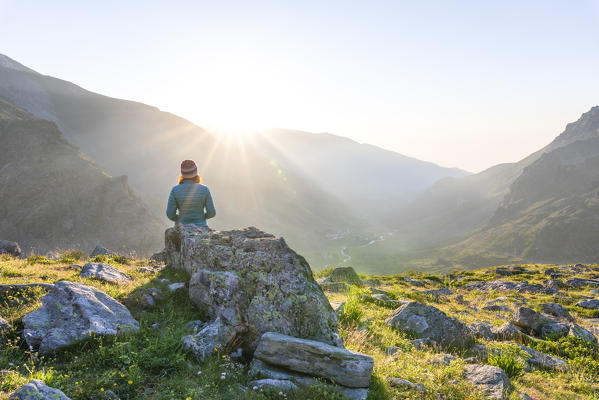 A girl is watching the Po Valley at sunrise (Fiorenza Lake, Pian del Re, Monviso Natural Park, Po Valley, Crissolo, Cuneo province, Piedmont, Italy, Europe) (MR)