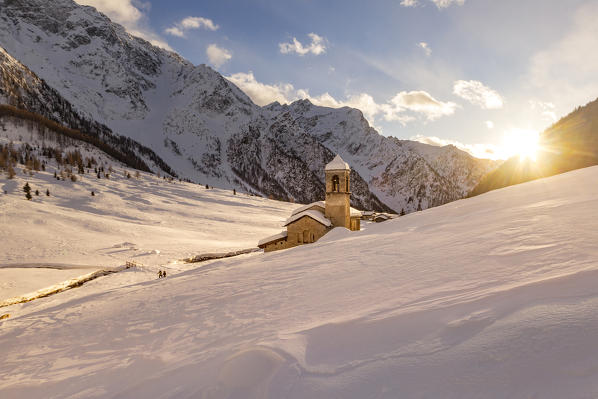 Alpine church of San Bernardo at sunset light in a mountain valley during winter season. Rezzalo valley, SOndalo, Sondrio district, Valtellina, Alps, Lombardy, Italy, Europe.