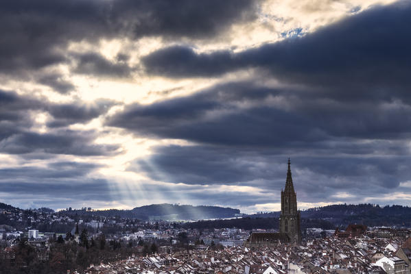 Sun ray between clouds above the Münster Cathedral. Bern, Canton of Bern, Switzerland, Europe.