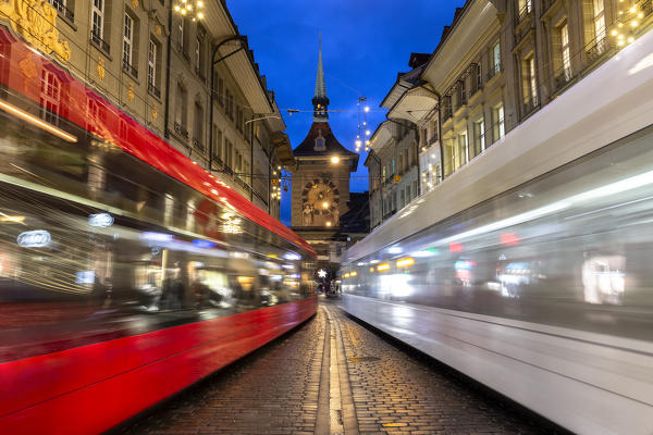 Transit of trams at Zytglogge tower at dusk. Bern, Canton of Bern, Switzerland, Europe.