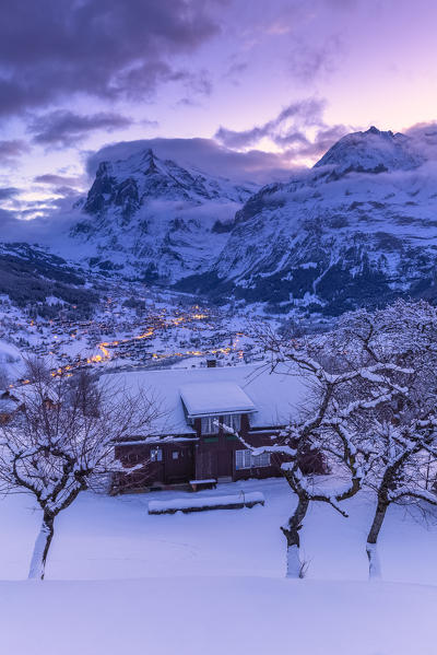 Traditional hut at sunrise after a snowfall. Grindelwald, Canton of Bern, Switzerland, Europe.