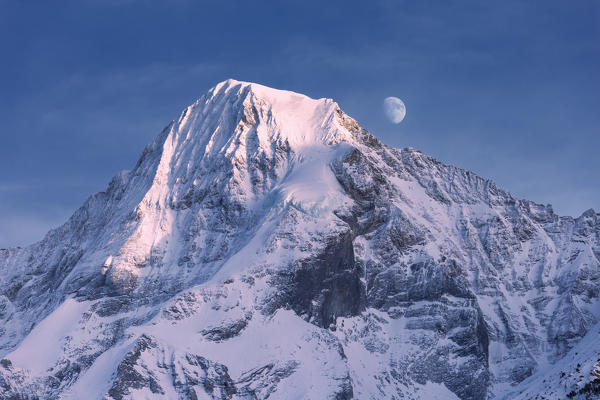 The moon during the sunset on the Monch peak. Murren, Lauterbrunnen valley, Canton of Bern, Switzerland, Europe.