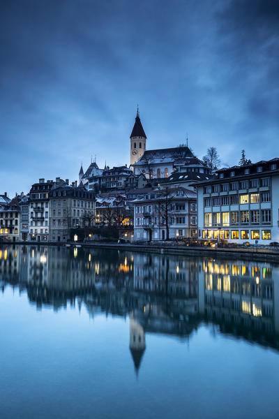 Historical center is reflected in the Aare river at dusk. Thun, Canton of Bern, Switzerland, Europe.