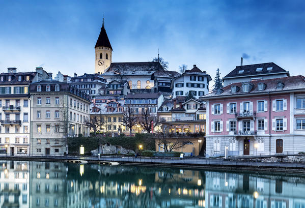 Historical center is reflected in the Aare river at dusk. Thun, Canton of Bern, Switzerland, Europe.