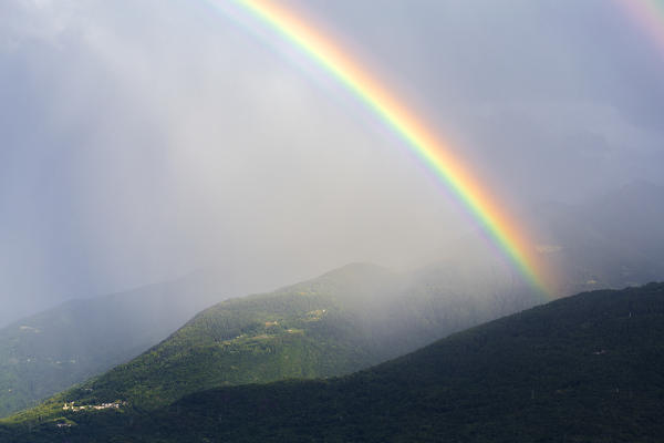 Rainbow during rainstorm. Orobie Alps, Valtellina, Lombardy, Italy, Europe.