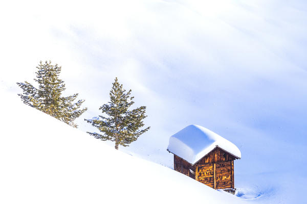 Traditional hut in the winter scenery. Livigno, Valtellina, Lombardy, Italy, Europe.