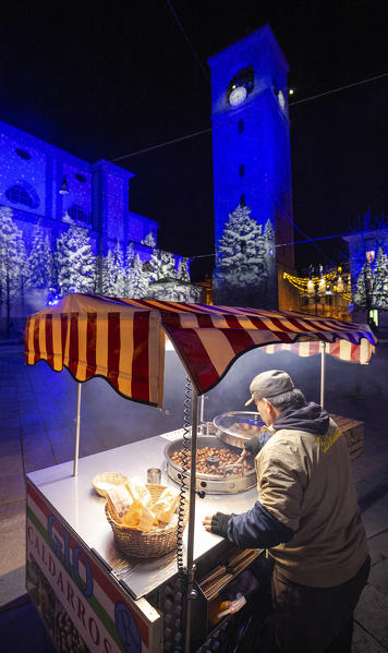 Chestnut seller in the square at night. Sondrio, Valtellina, Sondrio province, Italy, Europe.