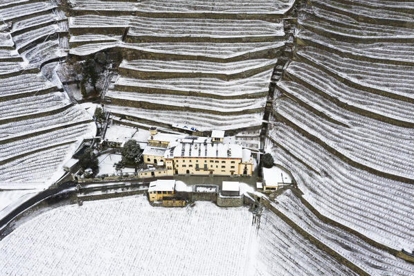 Aerial view of Tenuta La Gatta with snow. Bianzone, Valtellina, Sondrio province, Italy, Europe.