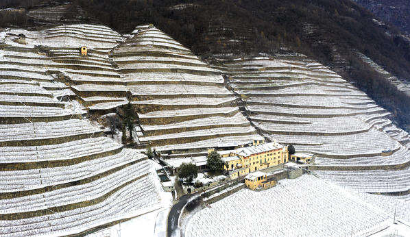 Aerial view of Tenuta La Gatta with snow. Bianzone, Valtellina, Sondrio province, Italy, Europe.