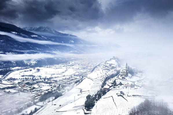 Aerial view of Castel Grumello and vineyards with snow. Montagna in Valtellina, Valtellina, Sondrio province, Italy, Europe.