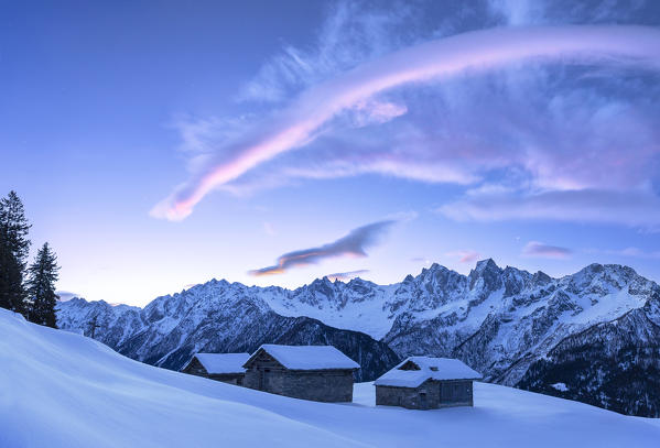 Stunning clouds above huts at sunrise. Soglio, Bregaglia Valley, Canton of Grisons, Switzerland, Europe.